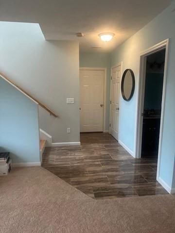 entrance foyer with baseboards, carpet flooring, and stairs