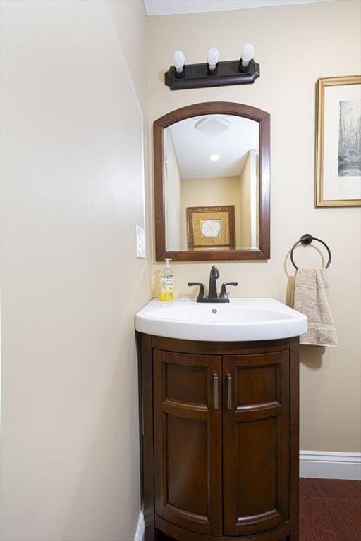 bathroom featuring baseboards, vanity, and wood finished floors