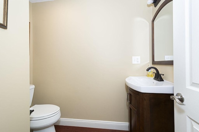 bathroom with vanity, toilet, and baseboards