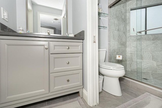bathroom with a shower stall, toilet, tile patterned flooring, and vanity