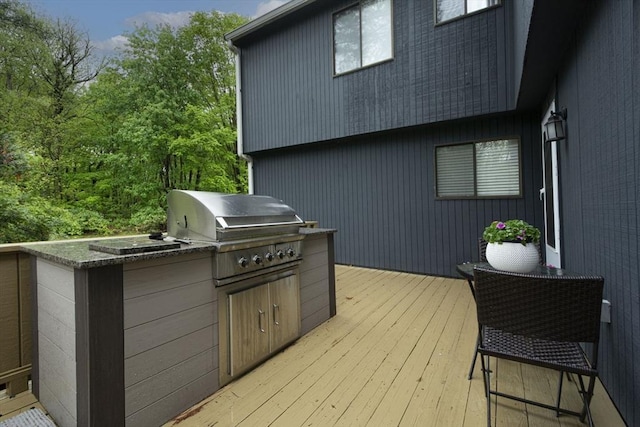 wooden deck with area for grilling and exterior kitchen