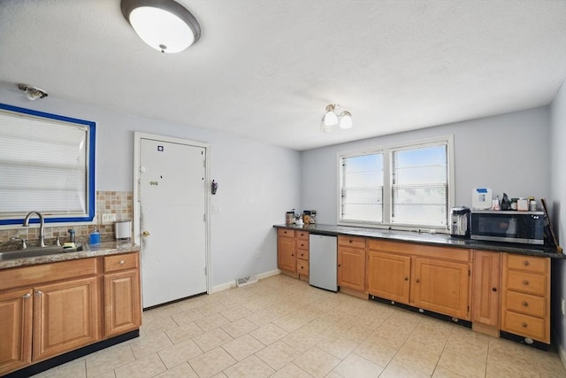 26 Hanna St, Quincy, MA 02169 - kitchen featuring stainless steel microwave, a sink, brown cabinetry, and decorative backsplash