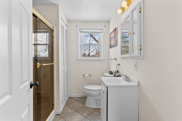 bathroom with vanity, toilet, tile patterned floors, and a shower with door