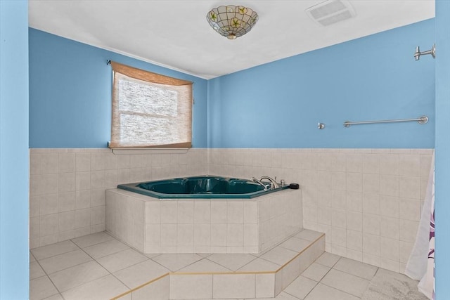 bathroom with a relaxing tiled tub and tile patterned floors