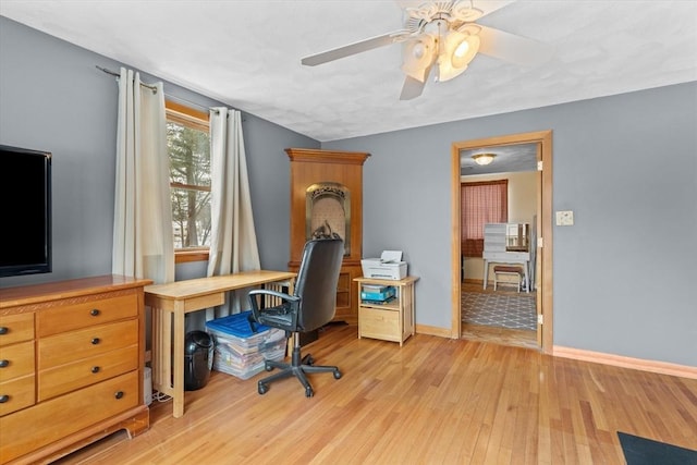 home office featuring light wood-type flooring and ceiling fan