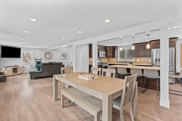 dining space with sink and light wood-type flooring