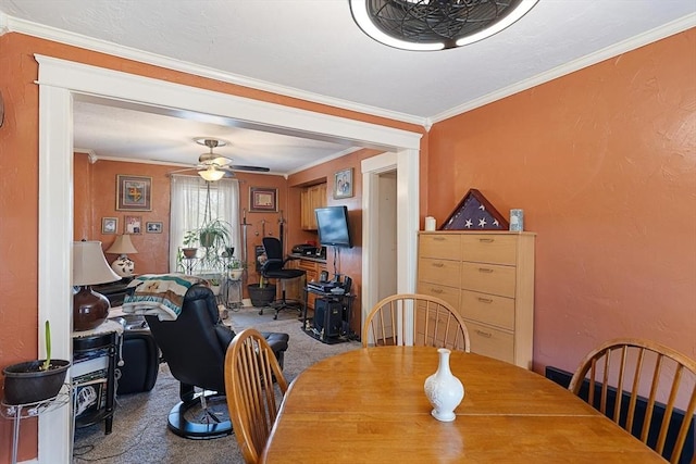 carpeted dining area featuring crown molding, a ceiling fan, and a desk