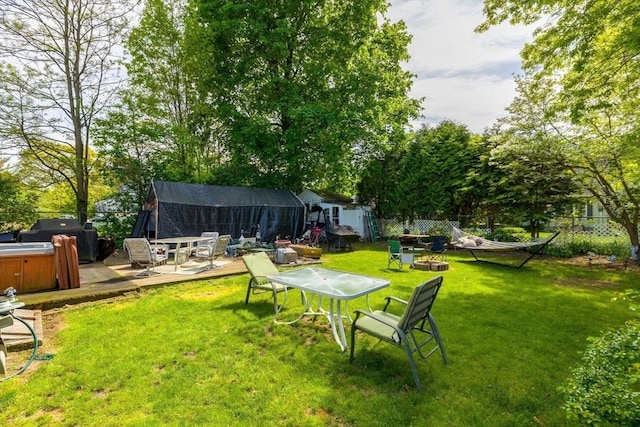 view of yard with a hot tub, an outdoor fire pit, and a patio area