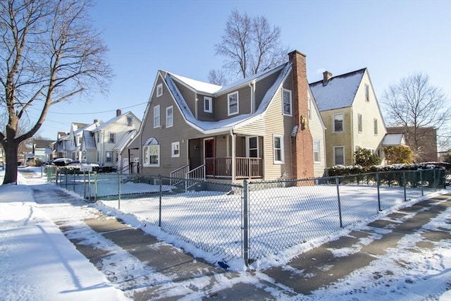 snow covered property with covered porch