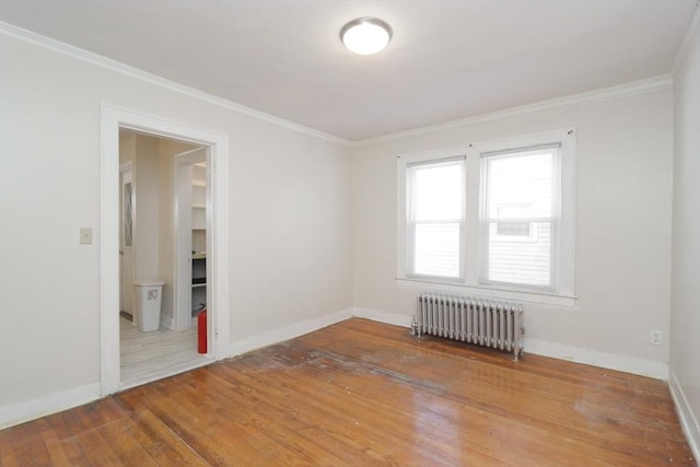 spare room featuring hardwood / wood-style flooring, radiator heating unit, and ornamental molding