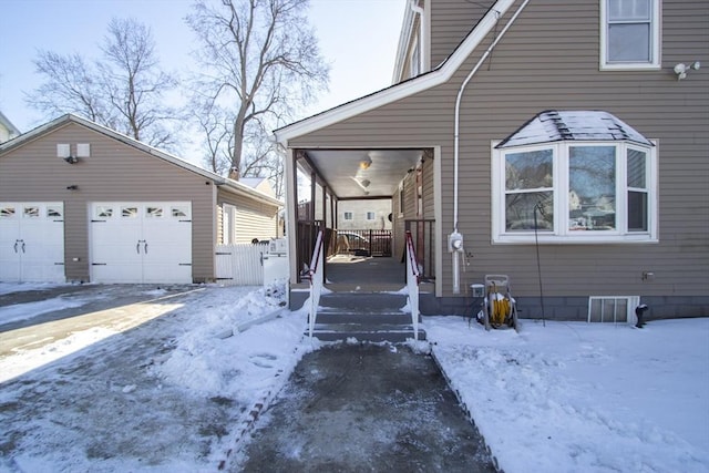 view of snowy exterior featuring an outdoor structure, a porch, and a garage