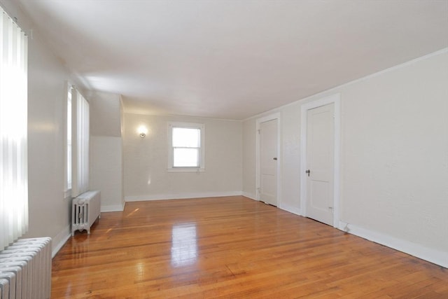 empty room featuring radiator heating unit and light wood-type flooring