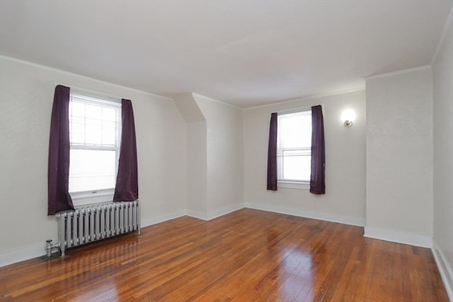 unfurnished room with crown molding, radiator, and dark hardwood / wood-style flooring