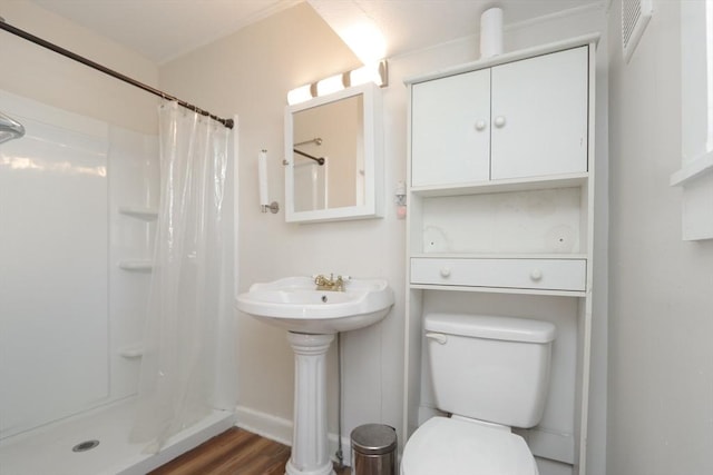 bathroom featuring sink, wood-type flooring, toilet, and walk in shower