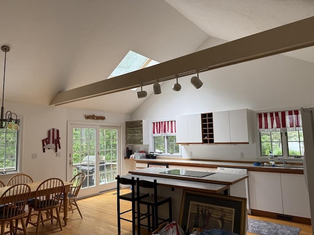183 Monomoscoy Rd, Mashpee, MA 02649 - kitchen featuring light wood-style floors, white cabinets, black electric stovetop, rail lighting, and high vaulted ceiling