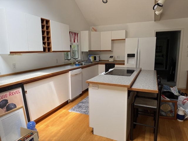 183 Monomoscoy Rd, Mashpee, MA 02649 - kitchen featuring white appliances, light wood-type flooring, white cabinetry, a kitchen bar, and a center island