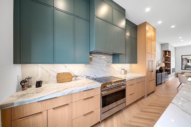 kitchen with stainless steel electric range, light stone counters, backsplash, recessed lighting, and wall chimney exhaust hood