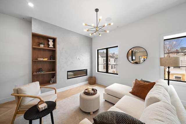 living area featuring a large fireplace, a chandelier, and baseboards