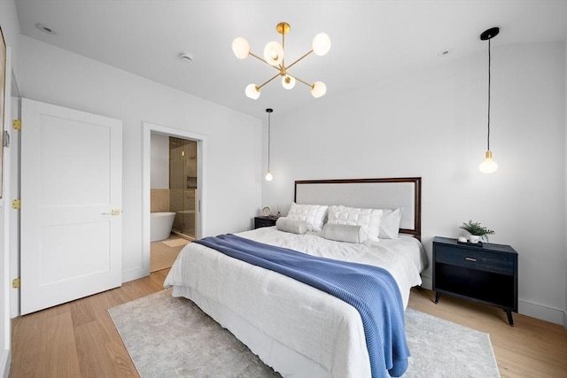 bedroom with a chandelier, wood finished floors, and ensuite bathroom