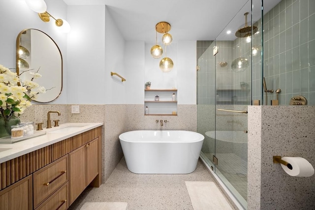 full bathroom with speckle patterned floor, a stall shower, double vanity, and a freestanding tub