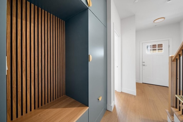 hall featuring light wood-type flooring and baseboards