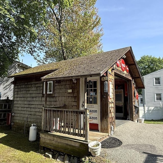 view of front of home featuring an outbuilding and a shingled roof