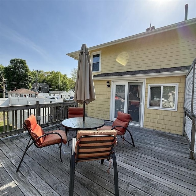 deck featuring outdoor dining area and fence