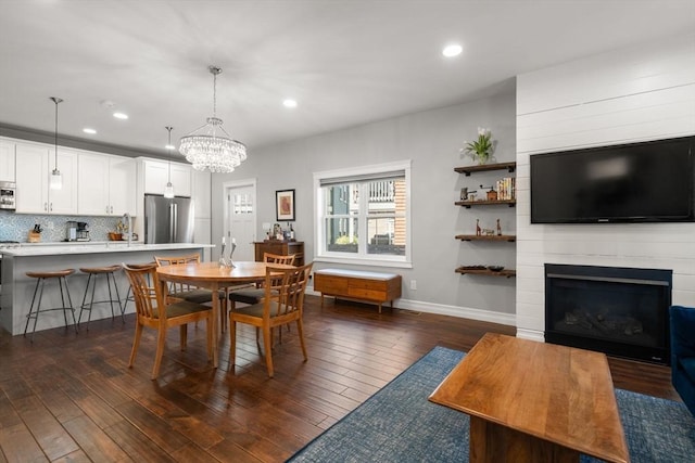 dining room featuring dark wood-type flooring, recessed lighting, baseboards, and a notable chandelier