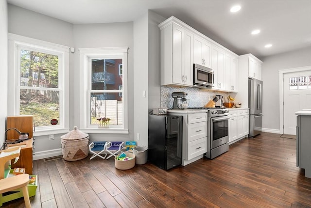 kitchen featuring light countertops, appliances with stainless steel finishes, recessed lighting, and dark wood finished floors