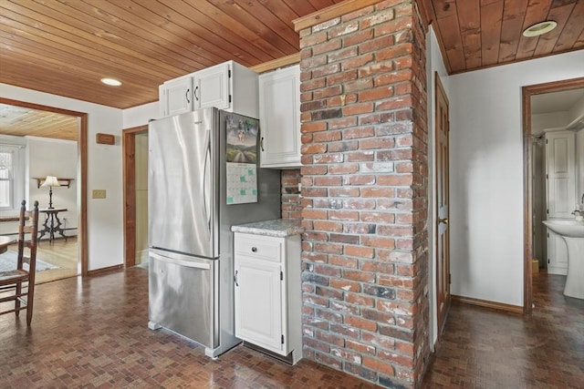 20 Houghton St, Webster, MA 01570 - kitchen featuring freestanding refrigerator, wooden ceiling, white cabinetry, brick patterned floors, and a baseboard heating unit