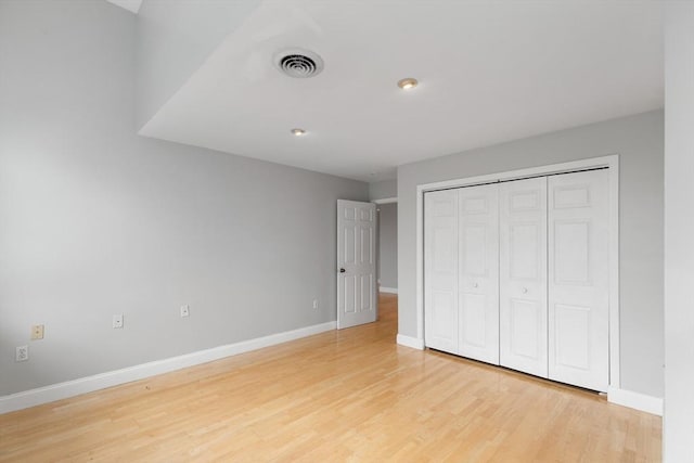 unfurnished bedroom featuring light hardwood / wood-style flooring and a closet