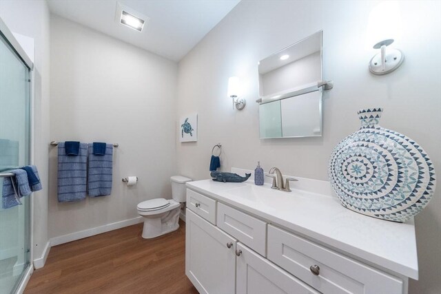 bathroom featuring vanity, toilet, and hardwood / wood-style floors