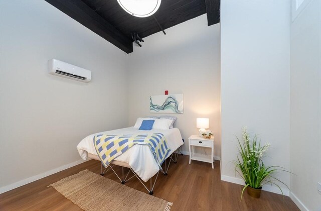 bedroom featuring a wall mounted air conditioner and hardwood / wood-style floors