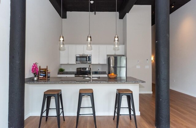 kitchen featuring light wood-type flooring, sink, stainless steel appliances, and white cabinetry