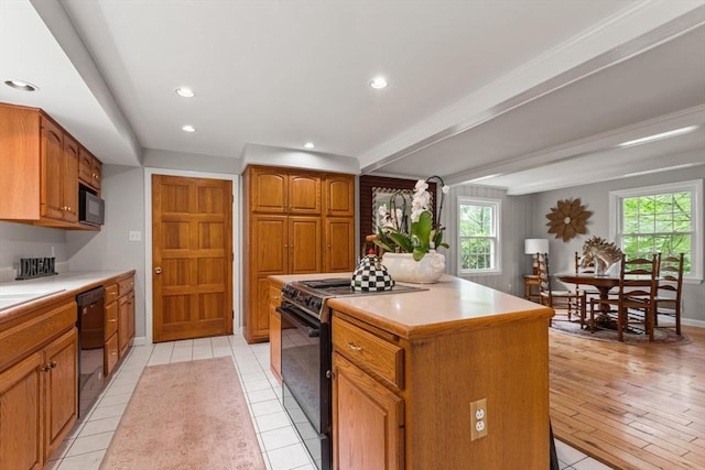 124 Hillside Rd, North Andover, MA 01845 - kitchen featuring black appliances, light countertops, brown cabinetry, recessed lighting, and a center island