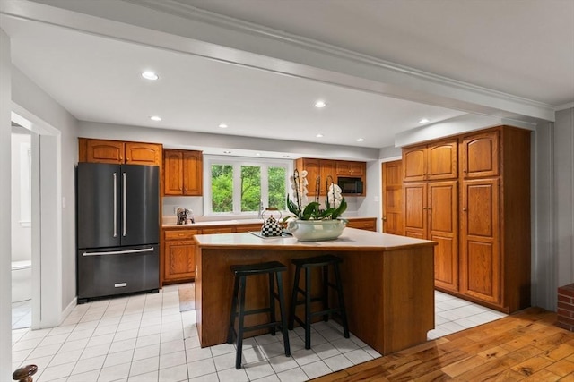 124 Hillside Rd, North Andover, MA 01845 - kitchen with freestanding refrigerator, black microwave, brown cabinetry, a center island, and light countertops