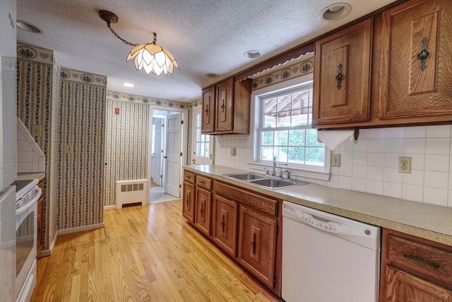 175 Knotty Pine Ln, Barnstable, MA 02632 - kitchen featuring white appliances, a sink, light wood finished floors, radiator, and brown cabinetry