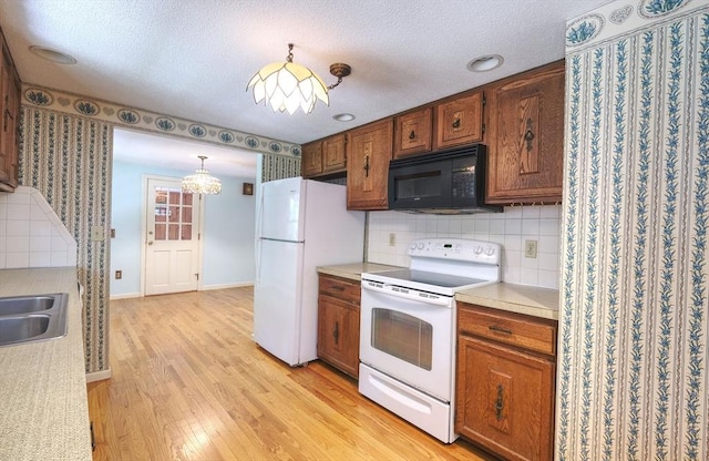 175 Knotty Pine Ln, Barnstable, MA 02632 - kitchen with white appliances, light wood-style floors, brown cabinetry, light countertops, and backsplash