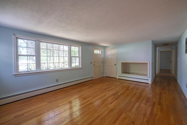 175 Knotty Pine Ln, Barnstable, MA 02632 - unfurnished living room featuring a baseboard heating unit, a textured ceiling, and light wood finished floors