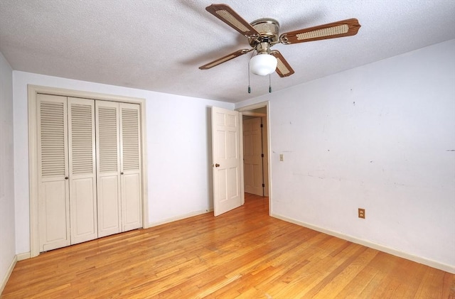 175 Knotty Pine Ln, Barnstable, MA 02632 - unfurnished bedroom with light wood-style flooring, baseboards, a closet, and a textured ceiling