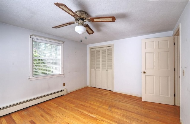 175 Knotty Pine Ln, Barnstable, MA 02632 - unfurnished bedroom with a baseboard radiator, light wood-type flooring, a textured ceiling, a closet, and a ceiling fan