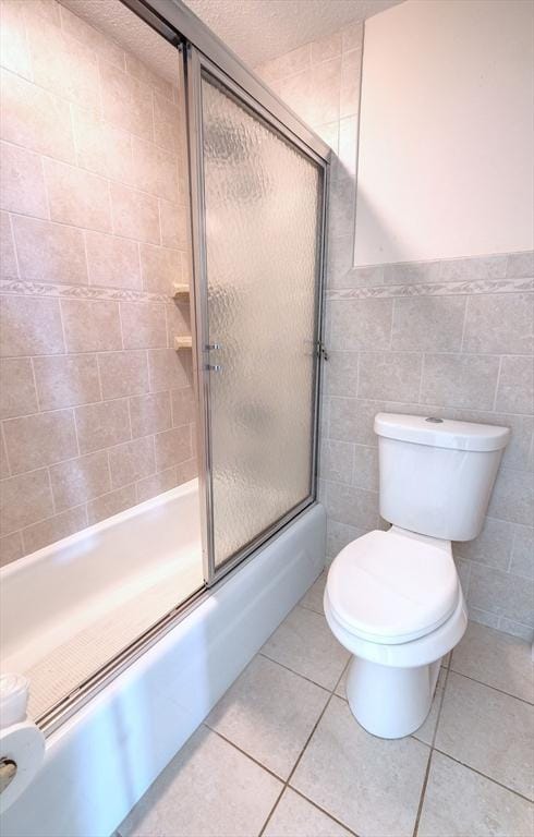 175 Knotty Pine Ln, Barnstable, MA 02632 - full bathroom featuring toilet, enclosed tub / shower combo, tile patterned floors, and tile walls