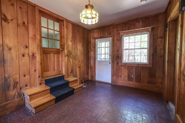 175 Knotty Pine Ln, Barnstable, MA 02632 - foyer entrance with brick patterned floors, stairway, and wood walls