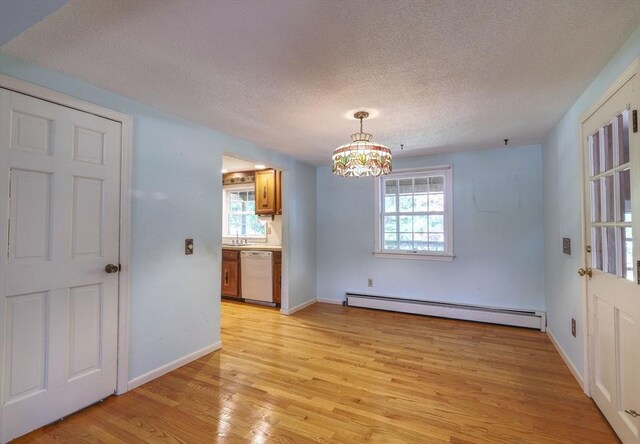 175 Knotty Pine Ln, Barnstable, MA 02632 - unfurnished dining area featuring a baseboard heating unit, light wood-style flooring, a textured ceiling, healthy amount of natural light, and baseboards