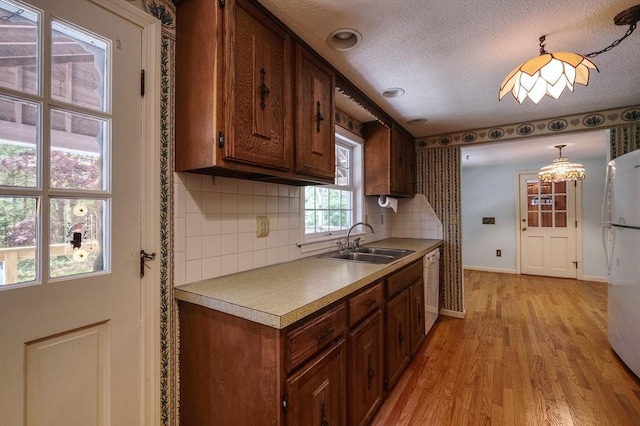 175 Knotty Pine Ln, Barnstable, MA 02632 - kitchen featuring a sink, white appliances, light wood-style floors, tasteful backsplash, and light countertops