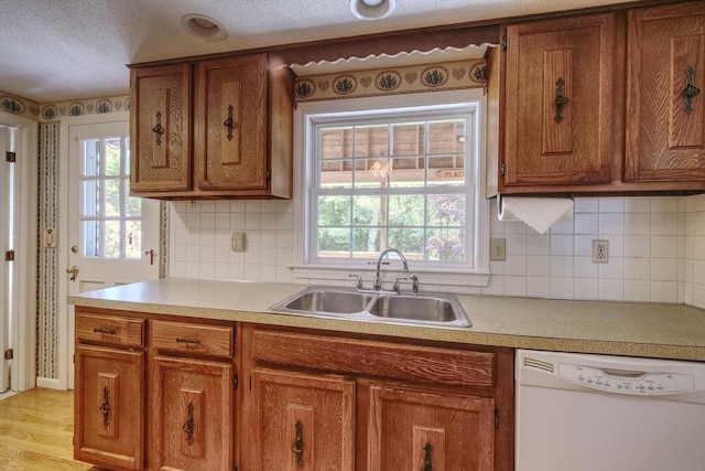 175 Knotty Pine Ln, Barnstable, MA 02632 - kitchen with dishwasher, a sink, brown cabinets, plenty of natural light, and a textured ceiling