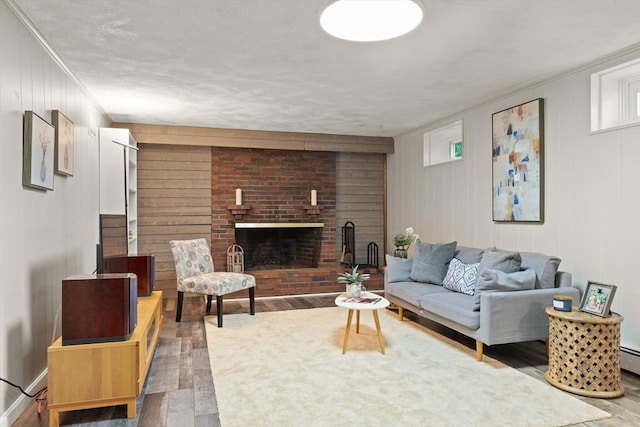 85 Loring Ave, Winchester, MA 01890 - living area featuring wood finished floors, wooden walls, a brick fireplace, and ornamental molding