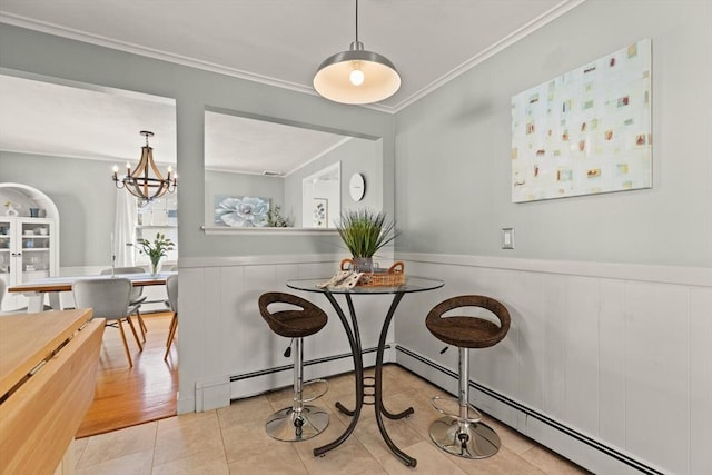 85 Loring Ave, Winchester, MA 01890 - tiled dining room with ornamental molding, a wainscoted wall, a baseboard heating unit, and a chandelier