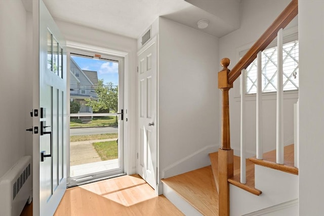 85 Loring Ave, Winchester, MA 01890 - foyer featuring radiator heating unit, healthy amount of natural light, stairway, and wood finished floors