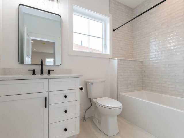 full bathroom with toilet, vanity, and tiled shower / bath